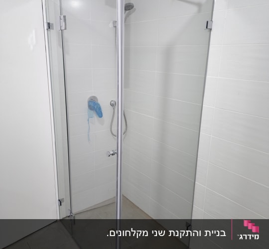 מקלחון זכוכית עם ראש מקלחת ומדף קטן
